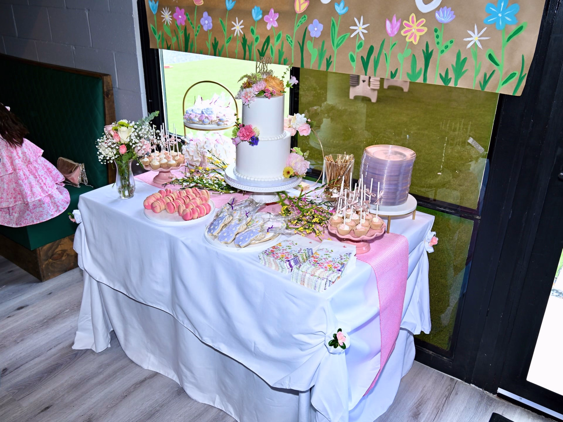 Outdoor baby shower at Botanic Beer Garden in Houston with floral decorations, guests celebrating, and garden-style seating.