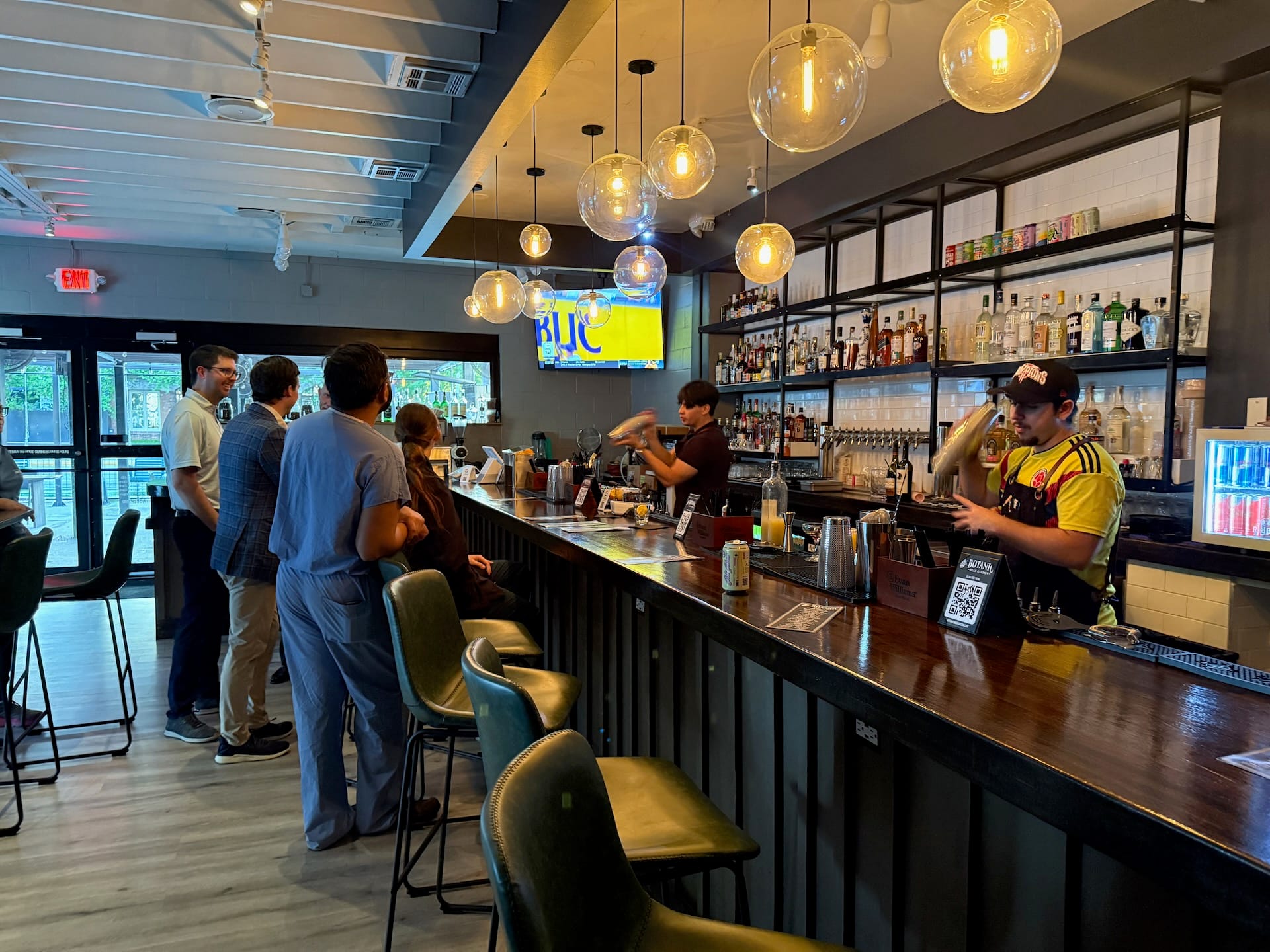 Corporate event at Botanic Beer Garden in Houston with colleagues networking in an open-air garden bar setting.
