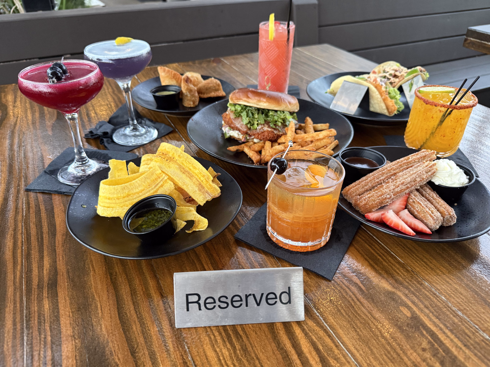 Cocktails and food at Botanic Beer Garden in Houston Heights with burgers, tacos, and appetizers