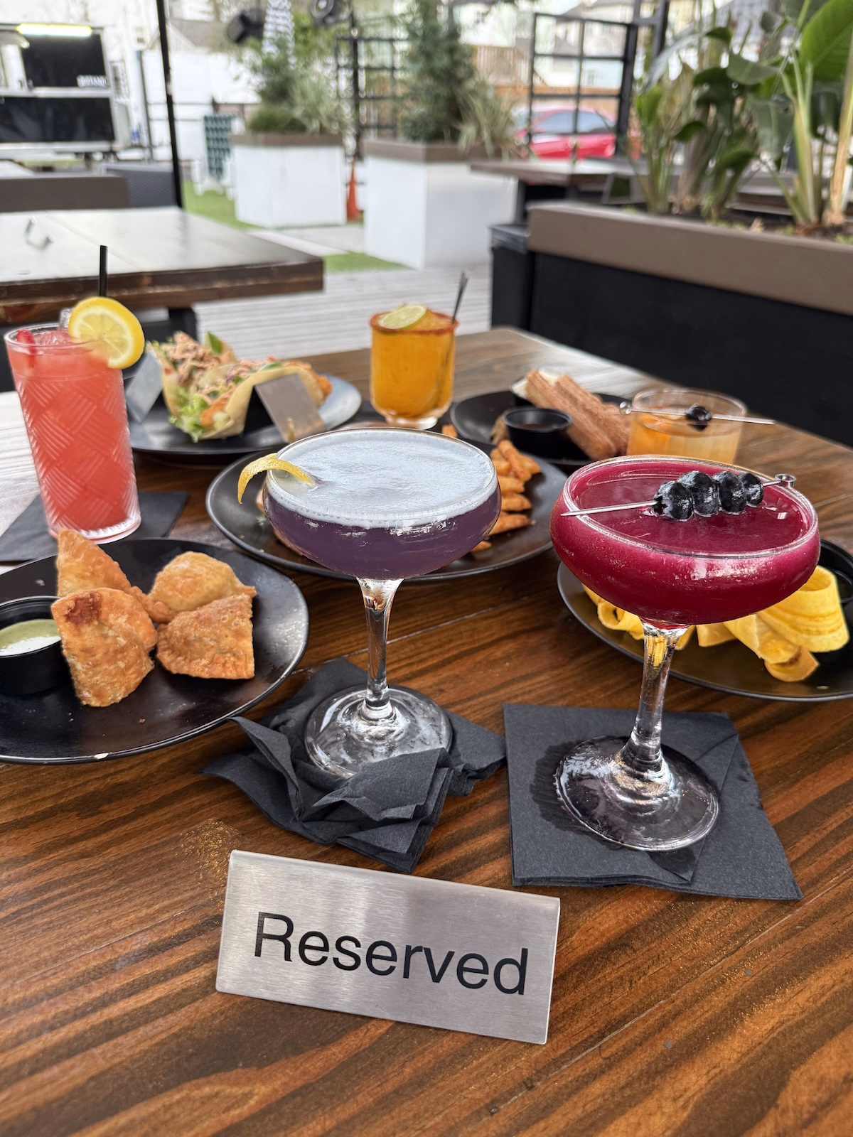 Reserved table with cocktails and food at Botanic Beer Garden in Houston Heights