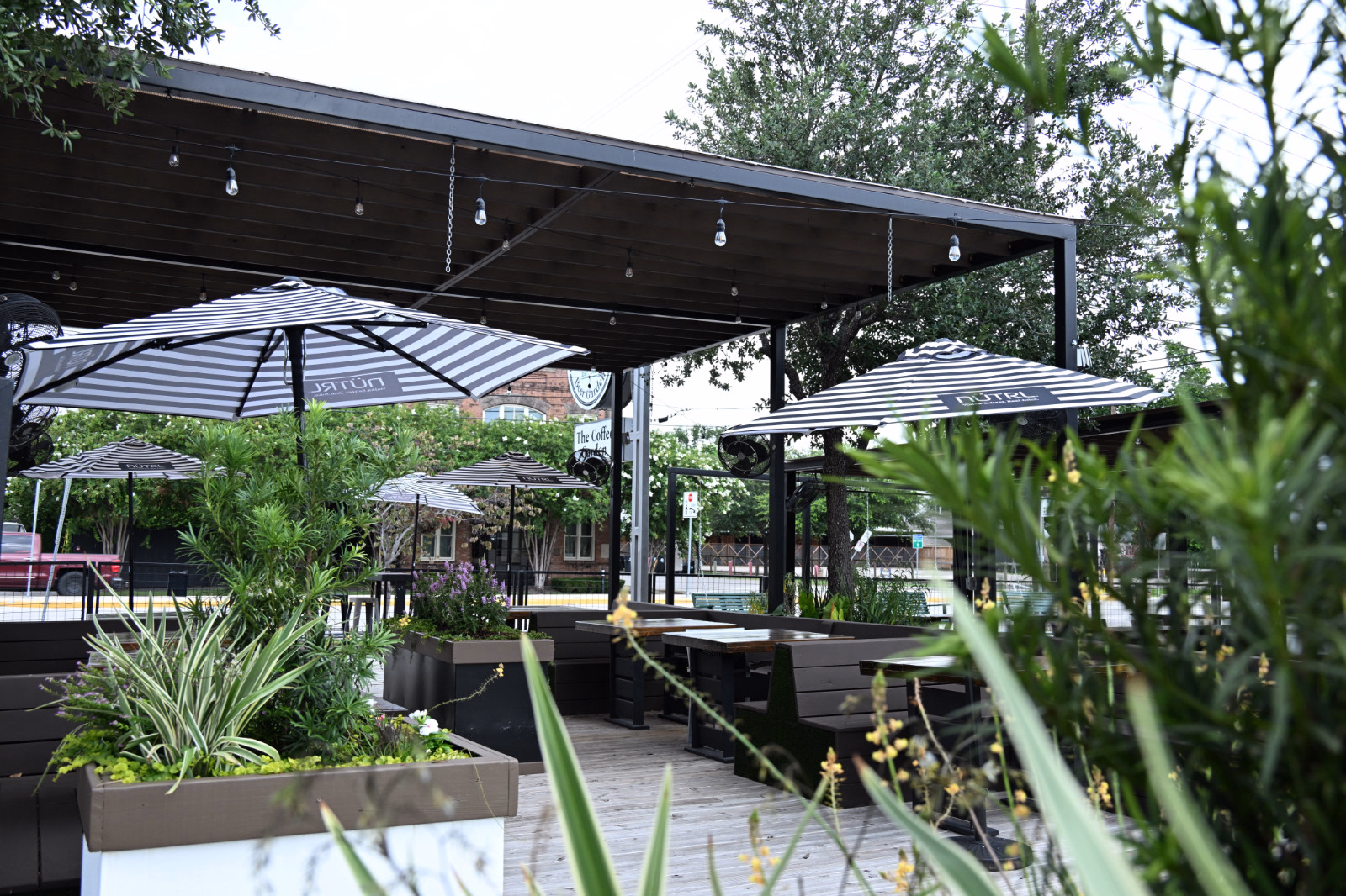 Covered Patio Tables at Botanic Beer Garden Large covered patio at Botanic Beer Garden in The Heights with shared tables and outdoor seating